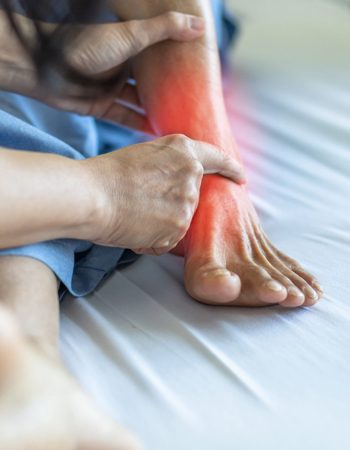 Imagen de un pie deportivo con dolor siendo examinado por un podólogo